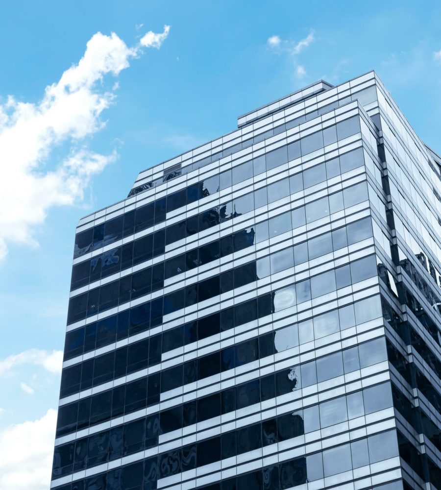 bottom-up-view-modern-office-building-with-glass-window-on-blue-sky-background-free-photo-scaled.jpg